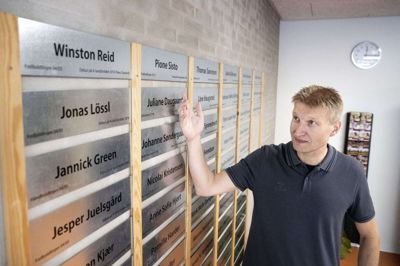 ISI-direktør Torben Østergaard ved »Wall og Fame« på skolen, hvor navnene på blandt andre Jonas Lössl, Simon Kjær, Joachim Andersen og Jonas Vingegaard springer i øjnene. Foto: Tom Laursen