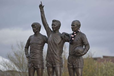 Foran Old Trafford står en statue med klubbens legendariske treenighed, som foruden Denis Law (i midten) består af Sir Bobby Charlton (til højre) og George Best (til venstre). (Arkivfoto).