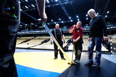 Koncentrationen var i top, da 800 kvadratmeter VM-gulv torsdag kom på plads i Boxen. Mellem det farvestrålende gulv og den rå beton er lagt et blødt mellemlag, der både isolerer og sørger for, at spillerne ikke bliver for hårdt belastet.