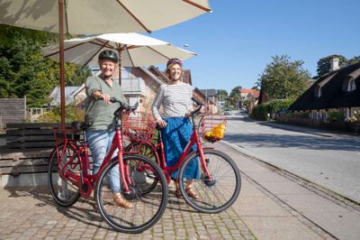 Charlotte Vindeløv (tv) og Hanne Brændstrup står bag et elcykelprojekt i Gl. Rye, hvor byen har fået stillet to cykler til rådighed af Region Midtjylland. Det er gået så godt, at cyklerne senere på året blive byens ejendom.