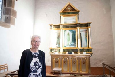 Tidligere menighedsrådsformand Ane Marie Mortensen foran alteret i Gjellerup Kirke. Den kunstneriske udsmykning af kirken var et af de aftryk, Bitten Damgaard satte i sit arbejde som medlem af menighedsrådet.