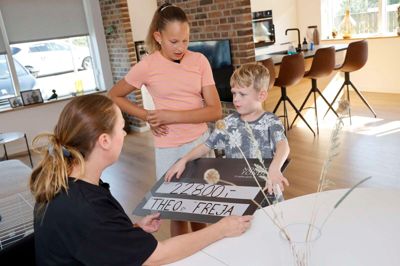Det var en stolt, spændt og forventningsfuld Freja Anni Kassentoft (i midten), der overrakte de mange penge til bedstevennen Theo Vestergaard Andersen. Her viser den blinde dreng sin mor, Malene Vestergaard Andersen, hvor mange penge nabopigen har samlet ind på få måneder.