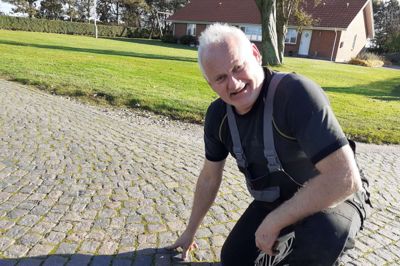Niels Peder Storbjerg ved sin private vej med den omkring 100 år gamle brostensbelægning, som Vejdirektoratet vil hive op for at lave en ny og bredere asfalteret vej.