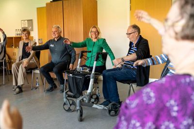 Ældreminister Mette Kierkgaard (M) fik smilet frem, da hun mandag formiddag blev inviteret til at deltage i et motions-koncept målrettet ældre. Det skete på Toftebo Plejecenter i Hammerum. Herning-borgmester Dorte West (V) deltog også på vegne af kommunen.