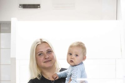 Camilla Christensen med sønnen Oliver på armen. Han har fået mor til at sælge Spjald Superkiosk. Foto: Malene Tswai
