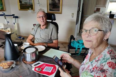 Irma og Svend Aage Jensen hjemme ved kaffebordet. Ny teknik i form af QR-koder og MobilePay er taget i brug, og selv om det driller en smule, lærer Irma Jensen også det med sin egen mobil. Foto: Jens Kristian Lynderup