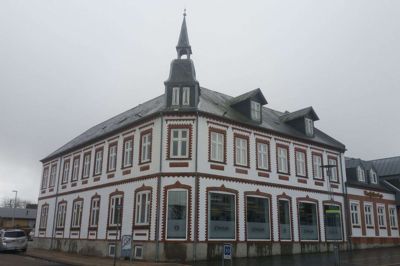 Vestjylland Forsikring mangler plads og vil bygge til ned ad Dyrvigsvej. Selskabet har købt det gule parcelhus i baggrunden og vil indrette nye offentlige p-pladser på den grund. Foto: Jesper Wind