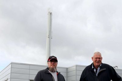 Det kan være svært at se røgen fra skorstenen på en overskyet dag. Men hvis det står til bestyrelsesformand Jan K. B. Pedersen (til højre), skal der gerne være slukket for skorstenen om sommeren. - Vi vil gerne køre uden flis om sommeren, men det kræver, at vi har el til rådighed, siger bestyrelsesformanden, der her ses sammen med driftslederen Flemming Joel Skjødt.