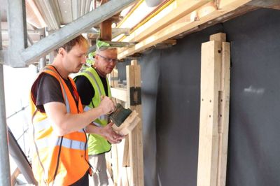 Håndværkerne Erik Batenburg (i orange vest) og Yngve Jönsson står for at lave bindingsværket på Ry stationsbygning.