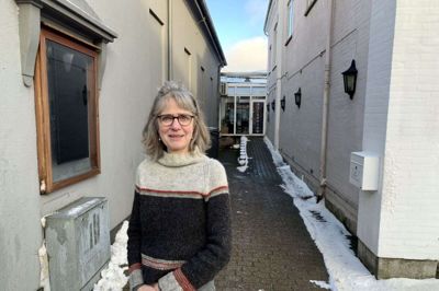Birgitte Karlshøj, daglig leder af Ry Biograf, i den smøge, som biografen forgæves forsøge at få råderet over, så biografen kan udvide. Det forhindrer en strid mellem ejer og forpagter af Hotel Ry, der er bygningen til højre, mens biografen ligger til højre. Foto: Claus Sonne