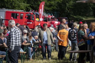 Folk samlede sig ved bænkene for at spise en pølse og drikke en fadøl i det gode vejr.