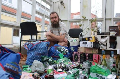 John Dybkjær er på sin vej til gymnasiet, hvor han arbejder, blevet opmærksom på de store mængder dåser, flasker og emballage i grøftekanten. Han er nu begyndt at tage kampen op. Det foreløbige resultat hober sig op i drivhuset.