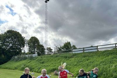 Fem piger på fodboldskole. De har haft det sjovt hele ugen.
