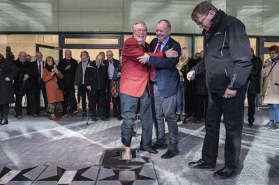 Bosse Johansson satte i november 2019 sin fod i cementen på Jysk Park og blev dermed optaget i klubbens Hall of Fame. SIF-direktør Kent Madsen støtter, mens Frederik Lysholt Hansen til højre holder øje med cementen.Foto: Martin Ballund
