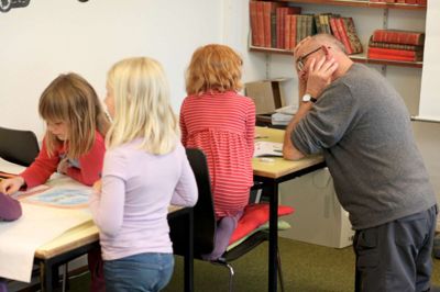 Ib Andersen har lagt hovedet i blød for at hjælpe Ashlee med danskopgaverne, mens Thea og Sofie ved nabobordet er i fuld gang med at tegne H.C. Andersens eventyr om Fyrtøjet