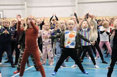Øjnene stærkt rettet mod storskæmen, mens der danses og synges løs til opvarmnings- og dinodans på Østre Skole.