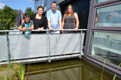 Lukas Halkjær Jørgensen (tv.), Vicki Rasmussen, Lars Kjær Pedersen og Manuela von Essen - alle beboere i Frisenborgparken i Ikast - er overrasket over odderens besøg i kvarterets fiskedamme. Foto: Ole Bitsch