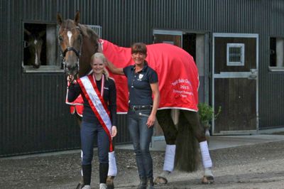 Brizard - også kaldet Rumle - flankeret af Marie Skov Olesen med weekends medaljehøst fra de nordiske mesterskaber og parrets træner Jeanet Friis Wagner fra Stald Wagner ved Herning. ?Privatfoto