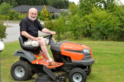 Eli Holm Nicolaisen på sin elskede havetraktor, der er nødvendig, hvis græsset skal holdes i ave på den store grund på Vibevej, hvor jubilaren har boet med Karin gennem snart 10 år. ?Foto: Flemming Thulstrup