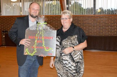 Anne-Marie Berg fra Landdistriktsrådet overrækker her det synlige bevis på Faurholts hæder til Ole Christiansen, formand for borgerforeningen i byen. ?Foto: Steen Hebsgaard