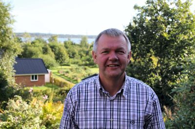 Frank Heidemann Sørensen tog et initiativ, som mange andre godt ville være med på, så der kan ske noget mere omkring Bølling Sø. Her ses Heidemann i sin have - med søen i baggrunden. ?Foto: Rasmus Viuff