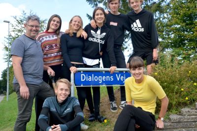 Forstander Bo Thorup glæder sig sammen med en gruppe elever over det nye skilt ved indkørslen til skolen. Skiltet er sat op for at sende et signal til omverdenen om, at skolen tager det med dialogen helt bogstaveligt. ?Privatfoto