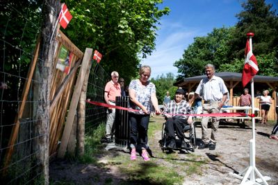 Birgit Linaa Pedersen fra Lokalrådet og projektgruppen klippede snoren. Helge Duus og Kirsten Kruse, også fra projektgruppen, ses til højre for snoreklipperen. Madpakkehuset er bagest i billedet. ?
