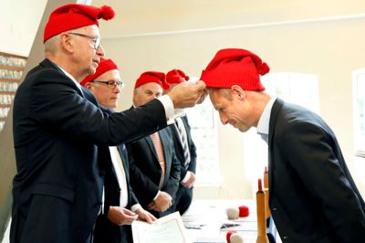 Oldermand i Hosebinderlauget, Niels Ole Vestergaard-Poulsen satte den røde hue på hovedet af direktør for Brands4Kids, Erik Andreæ. ?Foto: Henrik Ole Jensen