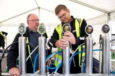 Formand Robert Bagger (t.v.) holder et vågent øje med festivalpladsen - alt skal gerne klappe. Også fadøllene, som Mads Christensen fra Carlsberg er ved at stille an. ?FOTO: TOM LAURSEN