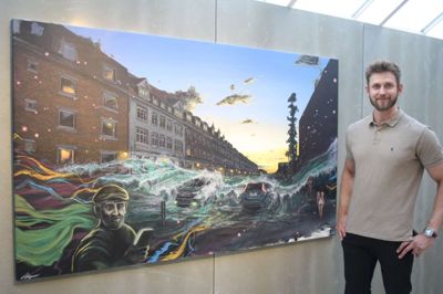 Anders Børgesen ved billedet »Flood«, som han blev inspireret til at male ved at kigge ud af vinduet. Udstillings-debutanten bor i blokken til højre.