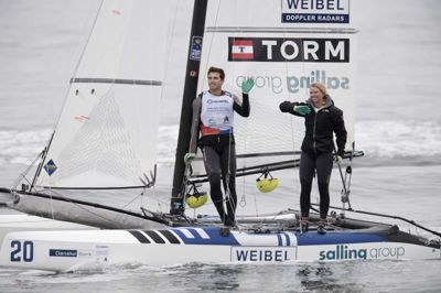 Bo Amstrup/Ritzau Scanpix. Lin Ea Cenholt og Christian Peter Lubeck lå i vandet i en time og ventede på, at vinden skulle tage til, men da det ikke skete, blev medalrace aflyst. Bagefter sejlede de to danskere ind foran tribunen på Aarhus havn og vinkede til de mange tilskuere, der var kommet for at se dem kæmpe om VM-medaljer.