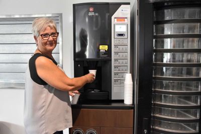 Susanne Wacker ved de to automater i cafeen, som alle kan benytte Foto: Steen Hebsgaard
