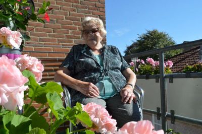 Karen Nielsen på sin blomstrende altan fyldt med masser af farver. ?FOto: Laila kempel