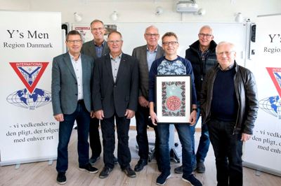 Henrik Amorsen med sit billede, der nu bliver trykt i tusindvis til gavn for lokalområdets ungdomsforeninger og Kræftens Bekæmpelse. Længst til højre er det Henning Busk fra Kræftens Bekæmpelse, der takkede repræsentanter fra Y's Men's-klubberne for arbejdet og støtten. ? Foto: Tom Laursen