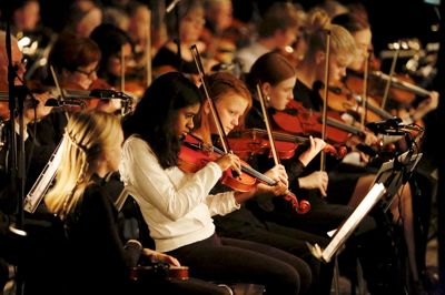 På forreste række i venstre side sad syv violinister fra musikskolen. De spillede med på mange numre, både med sine buer, men også med fingerspil. Ved nogle af numrene sad Jan Glud Østergaard ved deres side og støttede dem. Foto: Mikkel Mikkelsen