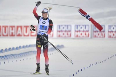 Jessica Gow/Ritzau Scanpix. Johannes Thingnes Bø havde tid til at snuppe et norsk flag på vej mod målet i mændenes 4 gange 7,5 kilometer stafet ved VM.