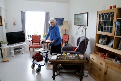 96-årige Dagny Clausen i sin lejlighed på Bøgildlund. Læg også mærke til rollatoren, som er nummer fire i rækken. De andre tre blev slidt op. Foto: Henrik Ole Jensen