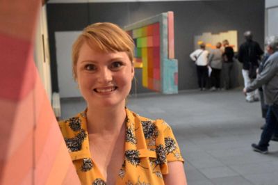 Astrid Marie Christiansen står ved siden af et af sine værker, hvor lærredet er blevet forvredet. Hun fortæller, at hun laver malerier, der er på nippet til at blive skulpturer