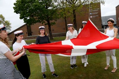 Årets første 13 studenter fra Ikast-Brande Gymnasium sprang ud i bededagsferien. Her er det lykkedes at samle de fleste af dem ved flagstangen, inden Dannebrog sendes til tops. ?Foto: Henrik Ole Jensen