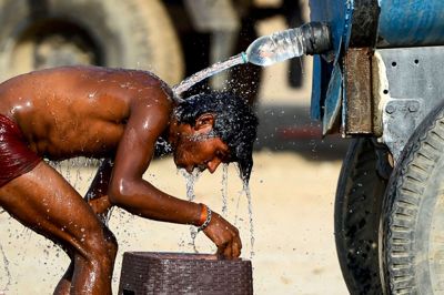 Sanjay Kanojia/Ritzau Scanpix. En indisk lastbilschauffør forsøger at køle ned ved hjælp af vand fra en vandtank. Termometeret målte lørdag 50,6 grader i ørkenbyen Churu, der ligger i delstaten Rajasthan.