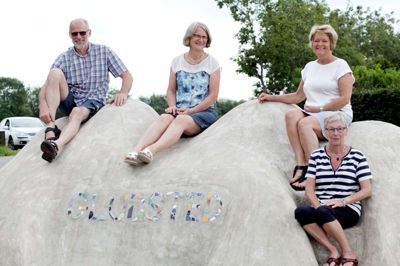 Fire af de mange frivillige, der gør afviklingen af Den Internationale Art Workshop i Gludsted mulig har her besteget »Travelling Island Gludsted - Sakushima« ved den nordlige indkørsel til byen. Fra venstre ses Torben Pedersen, Ingeborg Brandt, Jane Henneberg og forrest Tove Schwartz. Skulpturen blev fremstillet i 2017 af den japanske kunstner, Toru Matsuoka, som en del af projektet »Kunsthallen og landsbyerne«. Foto: Mikael Lund