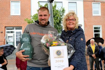 Rune Lyager Poulsen, Urban Street Zone, modtager Kulturprisen Focus Ikast-Brande 2019, som formand for Kultur- og Fritidsudvalget Helle Mathiasen (V) uddelte på torvet i Brande. Udover æren og blomster følger en vase designet af kommunens kendte keramiker Nina Lund. Foto: Villy Guldbrand Jensen