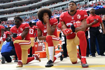 Billedet her er fra 2016, hvor NFL-spilleren Colin Kaepernick (i midten) og to holdkammerater knæler under den amerikanske nationalsang.