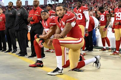 I 2016 skabte det debat, at quarterbacken Colin Kaepernick (th.) knælede under den amerikanske nationalmelodi. Siden fulgte flere spillere fra NFL og andre sportsligaer trop, men Kaepernicks sportslige karriere har været sat på pause siden 1. januar 2017.