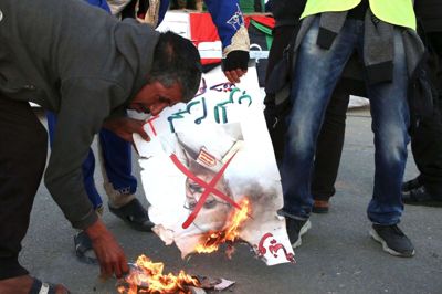 Libyske demonstranter brænder billeder af Khalifa Haftar under en demonstration i hovedstaden Tripoli fredag. Tyrkiske styrker skal støtte regeringen, der er under alvorligt pres fra Haftar.