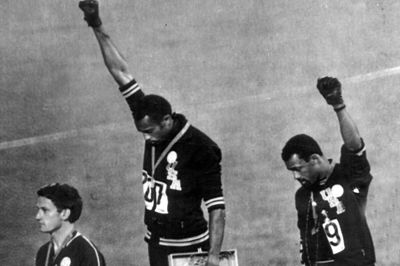 Under OL i 1968 demonstrerede løberne Tommie Smith (i midten) og John Carlos (til højre) med knyttede hænder under en medaljeceremoni for at sætte fokus på USA's behandling af afroamerikanske borgere. Den slags tillades ikke af IOC.