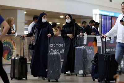Rejsende iført ansigtsmasker ankommer med fly i Dubai International Airport. Nu er alle fly til og fra Iran - med undtagelse af Teheran - suspenderet. (Arkivfoto)