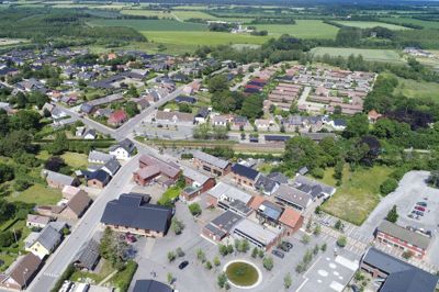 Bording er en by i vækst. Øverst til højre ses nye boliger skyde op på Kornblomsten, der er første etape i en strukturplan, som på sigt kan rumme 250 nye parcelhuse. I forgrunden ses en del af den byfornyelse, som Realdania og Ikast-Brande Kommune skød i gang i 2011. Den tidligere brandtomt efter Superbest-købmanden er nu omdannet til et spændende og velbesøgt samlingspunkt ved navn Mødestedet - med tilhørende skaterbane, legeplads og egen lille sø. Der er skabt langt bedre forbindelse mellem skole og midtby, og stationsområdet har fået et markant løft af sit udseende. Foto: Flemming Hansen