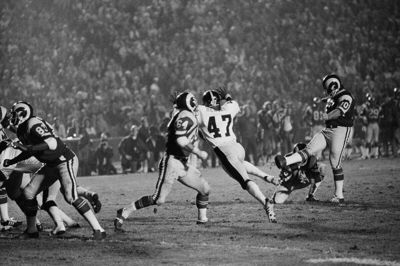 Kickeren Tom Dempsey (til højre), som her ses tørne ud for Los Angeles Rams i 1975, er død efter at være smittet med coronavirus.