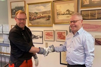 Corona eller ej - en virksomhedshandel skal afsluttes med et håndtryk. Af sundhedsmæssige hensyn blev det dog med arbejdshandskerne på. Her er det tredje generation hos Jens Konrad A/S, Jens Christian Beck, til venstre og Bo Marius Christensen fra Ikast til højre. Foto: Pr-foto